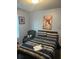 Comfortable bedroom with striped bedding, decorative wall art, and a cozy chair at 713 Dove Tree Ln, Social Circle, GA 30025