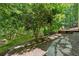 Expansive backyard with stone pathway, tiered landscaping, and mature trees at 4050 Arrow Head Trl, Cumming, GA 30041