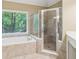 Bathroom featuring a soaking tub and a separate shower with a glass door and tile surround at 4050 Arrow Head Trl, Cumming, GA 30041