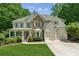 Charming two-story home with stone accents, covered porch, three-car garage, and lush landscaping at 4050 Arrow Head Trl, Cumming, GA 30041
