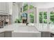 Farmhouse sink with modern faucet, quartz countertops, and view to living room in updated kitchen at 4050 Arrow Head Trl, Cumming, GA 30041