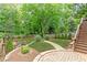 Lush backyard featuring a brick patio, landscaped garden beds, and stairs to the upper-level deck at 79 Anniston Se Ave, Atlanta, GA 30317