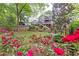Beautifully landscaped backyard with colorful roses and a view of the home's tiered deck and fire pit area at 79 Anniston Se Ave, Atlanta, GA 30317