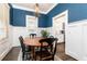 Dining room boasts blue walls with white wainscoting, dark floors, and chandelier, adjacent to a butler's pantry at 79 Anniston Se Ave, Atlanta, GA 30317