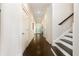 Long hallway showcasing hardwood floors, white trim, and a staircase with stained treads and white risers at 79 Anniston Se Ave, Atlanta, GA 30317