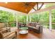 Relaxing screened porch with comfortable seating, ceiling fan, wooden flooring, and wooded view at 79 Anniston Se Ave, Atlanta, GA 30317