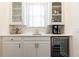 Wet bar features white cabinets, subway tile backsplash, beverage fridge, and glass-front cabinets at 79 Anniston Se Ave, Atlanta, GA 30317