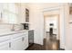 Wet bar offers white cabinets, subway tile backsplash, beverage fridge, and glass-front cabinets at 79 Anniston Se Ave, Atlanta, GA 30317