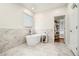 Modern bathroom featuring a freestanding tub, marble accents, and a walk-in closet providing abundant storage at 2798 Glenlocke Nw Cir, Atlanta, GA 30318