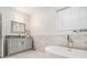Well-lit bathroom featuring a sleek vanity, stylish fixtures, a soaking tub, and marble tiled walls at 2798 Glenlocke Nw Cir, Atlanta, GA 30318
