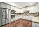 A modern kitchen featuring granite countertops, a stainless-steel refrigerator, and white cabinetry at 2798 Glenlocke Nw Cir, Atlanta, GA 30318