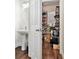 A compact powder room and open closet featuring a pedestal sink and white door at 2798 Glenlocke Nw Cir, Atlanta, GA 30318