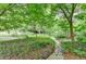 Serene backyard landscape with stone pathway winding through lush greenery and trees at 3081 Anthony Dr, Decatur, GA 30033