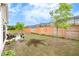 Fenced backyard featuring a brick retaining wall and mature trees at 463 Marston Pass, Acworth, GA 30102