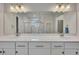 Bathroom with dual vanity, white cabinets, chrome hardware, and a view of the glass shower at 463 Marston Pass, Acworth, GA 30102