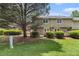 Back of townhome with a well-kept lawn and patios partially visible behind neatly trimmed bushes at 6900 Roswell Rd # F6, Atlanta, GA 30328
