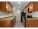 Modern kitchen with granite countertops, stainless appliances, and wood cabinets over hardwood floors at 6900 Roswell Rd # F6, Atlanta, GA 30328