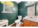 Cozy bathroom with green walls, wood floors, single vanity, and a window at 138 Fox Creek Dr, Woodstock, GA 30188