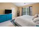 Bedroom showcasing a cozy bed, a blue dresser, and natural light from the window at 138 Fox Creek Dr, Woodstock, GA 30188