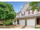 Exterior showcasing a covered porch, a two-car garage, and a well-manicured front yard at 138 Fox Creek Dr, Woodstock, GA 30188