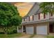 Exterior showcasing sunset views, a covered porch, a two-car garage, and a well-manicured front yard at 138 Fox Creek Dr, Woodstock, GA 30188