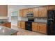 Traditional kitchen featuring wooden cabinets, granite counters, and black appliances at 481 Jefferson Chase Se Cir, Atlanta, GA 30354
