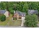 Stunning aerial view of a brick home with a gray roof, showcasing its landscaped yard, long driveway and proximity to mature trees at 5344 Saint Martins Se Ct, Mableton, GA 30126