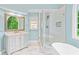 Bright bathroom featuring white cabinets, a glass shower, marble floors, and a large vanity mirror at 5344 Saint Martins Se Ct, Mableton, GA 30126