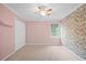Bright bedroom featuring floral accent wall, ceiling fan, neutral carpet, and double door closet at 5344 Saint Martins Se Ct, Mableton, GA 30126