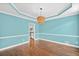 Dining room showcasing hardwood floors, blue walls, a chandelier, and decorative ceiling trim at 5344 Saint Martins Se Ct, Mableton, GA 30126