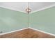 Neutral green living room with hardwood floors, a decorative chandelier, and base trim at 5344 Saint Martins Se Ct, Mableton, GA 30126