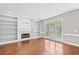 Spacious living room with hardwood floors, built-in bookshelves, a fireplace, and a large window at 5344 Saint Martins Se Ct, Mableton, GA 30126