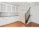 Interior shot of a staircase with iron railings and a built in storage unit with glass doors at 5344 Saint Martins Se Ct, Mableton, GA 30126