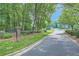 Scenic street view entering Stoneybrook subdivision with lush trees and manicured lawns, and a stone entrance sign at 5344 Saint Martins Se Ct, Mableton, GA 30126