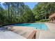 A refreshing community swimming pool surrounded by tall trees and a spacious deck for lounging at 5344 Saint Martins Se Ct, Mableton, GA 30126