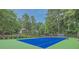 A well-maintained community tennis court is surrounded by lush greenery with a home visible in the background at 5344 Saint Martins Se Ct, Mableton, GA 30126