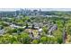 An aerial view showcases homes surrounded by abundant trees in a suburban neighborhood, with a cityscape visible beyond at 115 Peachtree Memorial Nw Dr # C1, Atlanta, GA 30309