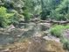 Scenic creek view featuring a wooden bridge, rocks, and lush greenery at 115 Peachtree Memorial Nw Dr # C1, Atlanta, GA 30309