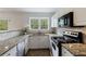 Well-lit kitchen with stainless steel appliances, granite countertops, and white cabinetry at 115 Peachtree Memorial Nw Dr # C1, Atlanta, GA 30309