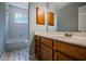 Bright bathroom featuring a tub with white tile surround and a vanity with wood cabinets at 135 Greenmont Downs Trce, Alpharetta, GA 30009