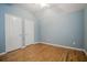 Comfortable bedroom with hardwood floors, light blue walls, and two doors for easy access at 135 Greenmont Downs Trce, Alpharetta, GA 30009