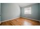 This bedroom features hardwood floors, a vaulted ceiling, a large window, and neutral paint at 135 Greenmont Downs Trce, Alpharetta, GA 30009