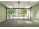 Cozy sunroom with wall-to-wall windows and sliding doors, providing access to a private outdoor deck at 135 Greenmont Downs Trce, Alpharetta, GA 30009