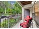 Relaxing outdoor balcony space featuring two red cushioned chairs with a view of greenery and the neighborhood street at 5559 Glenridge Dr # 1103, Sandy Springs, GA 30342