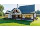 Beautiful backyard showing the home's covered patio, and brick accents at 71 Ramey Rd, Sugar Hill, GA 30518