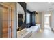 Stunning bathroom featuring a soaking tub, dual vanity, round mirrors, and black marble accent wall at 71 Ramey Rd, Sugar Hill, GA 30518
