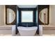 Luxurious bathroom featuring dual vanities, a freestanding tub, and black tiled walls and matching floors at 71 Ramey Rd, Sugar Hill, GA 30518