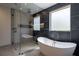 Elegant bathroom with a freestanding tub, glass shower, and marble accent wall at 71 Ramey Rd, Sugar Hill, GA 30518