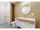 Bright bathroom with a white vanity, round mirror, wood accents, and convenient shelving unit at 71 Ramey Rd, Sugar Hill, GA 30518