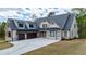 Charming two-story home with a three-car garage, stone accents, and a beautifully landscaped front yard at 71 Ramey Rd, Sugar Hill, GA 30518